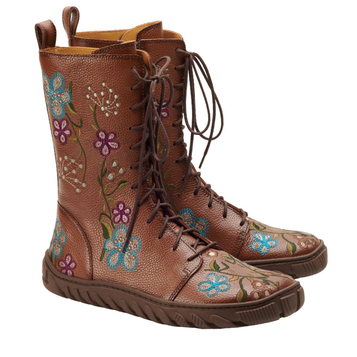 Die DOQS Flower Boots von ZAQQ zeichnen sich durch ein charmantes Design mit braunen Schnürdetails und Blumenstickereien aus, die an den Seiten blaue, violette und weiße Blumen zeigen. Diese aus hochwertigem Nappaleder gefertigten Boots bieten mit ihrer robusten Sohle und der praktischen Schlaufe an der Rückseite einen Retro-Charme.