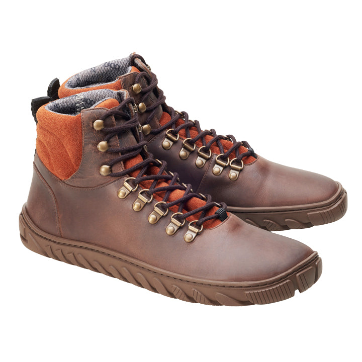 Ein Paar WALQ Brown Waterproof Wanderstiefel von ZAQQ, gefertigt aus Veloursleder, mit schwarzen Schnürsenkeln und Messingösen. Die Stiefel haben eine robuste Sohle und gepolsterte orangefarbene Knöchelpolster, perfekt nebeneinander auf weißem Hintergrund positioniert.