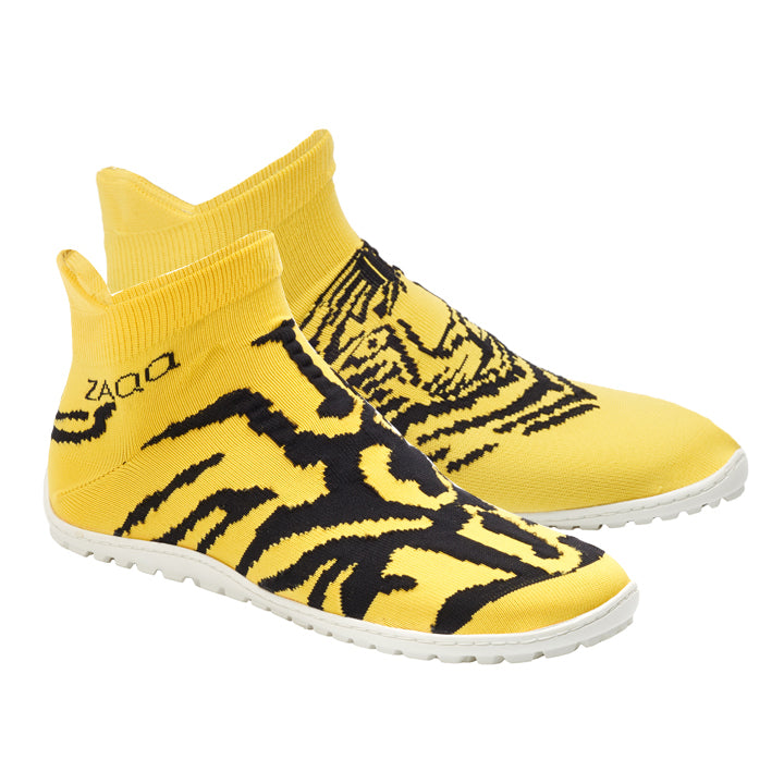 Wir präsentieren Ihnen die auffälligen SOQQ Tiger Yellow von ZAQQ. Diese unverwechselbaren Sockenschuhe bestechen durch ein kompliziertes abstraktes schwarzes Muster auf einem leuchtend gelben Design mit hohem Knöchel. Mit weißen Sohlen und dem ZAQQ-Logo in der Nähe der Ferse bieten sie ein stilvolles und dennoch bequemes Tragegefühl, das dem von Barfußschuhen ähnelt.