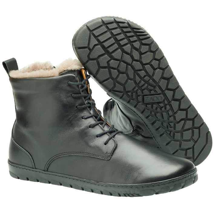 Wir präsentieren den QUINTIC Winter Black von ZAQQ – stilvolle Lederstiefel mit Schnürung, strukturierter Gummisohle und weichem Lammfell-Futter, perfekt für den Winter. Ein Stiefel steht aufrecht, während der andere geneigt ist und das aufwendige Sohlenmuster zur Schau stellt.