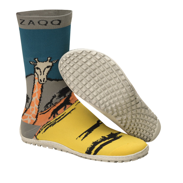 Die SOQQ Giraffe Yellow Socken zeigen ein lebendiges Safari-Motiv in Gelb-, Blau- und Orangetönen, begleitet von einer strukturierten Sohle. Sie bestehen aus Strickgewebe und bieten einen Komfort ähnlich einem Barfußschuh. Die Oberseite der Socken ist elegant mit dem Markennamen ZAQQ in Grau verziert.