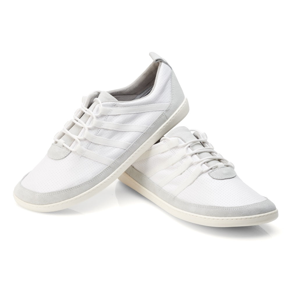 Wir präsentieren den SPARQ Low White von ZAQQ: Ein Paar weiße Sneaker mit hellgrauen Akzenten, einem strukturierten Design und weißen Schnürsenkeln. Ein Schuh liegt schräg auf der Seite und lehnt elegant an dem anderen vor einem schlichten weißen Hintergrund. Ideal für alle, die sowohl Stil als auch Komfort schätzen.