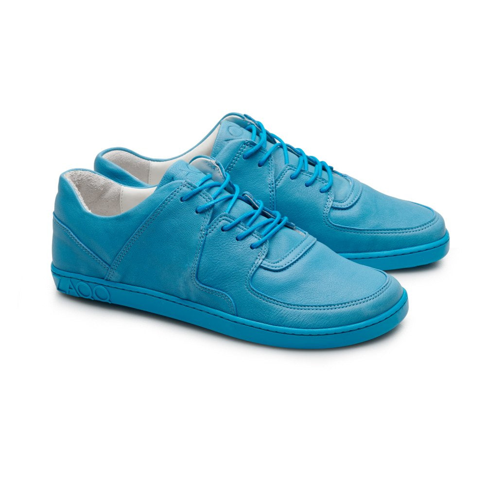 Ein Paar leuchtend blaue IVIQ Blue-Schuhe von ZAQQ mit glattem Lederfinish und passenden Schnürsenkeln. Diese eleganten, modernen Sneaker werden vor einem weißen Hintergrund präsentiert, wodurch ihre markante Farbe perfekt hervorgehoben wird.