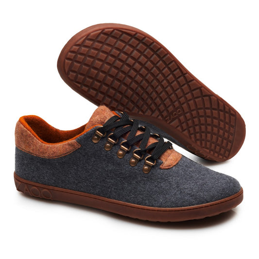 Wir präsentieren den LIQE Grey Toffee von ZAQQ: ein schickes Paar grauer Outdoor-Schuhe mit braunen Gummisohlen und roten Akzenten. Diese Barfußschuhe sind mit schwarzen Schnürsenkeln ausgestattet, die durch Metallösen geführt sind, und einer strukturierten Sohle, die für Strapazierfähigkeit und Halt sorgt. Ideal für alle, die bei jedem Schritt Wert auf Komfort und Stil legen.