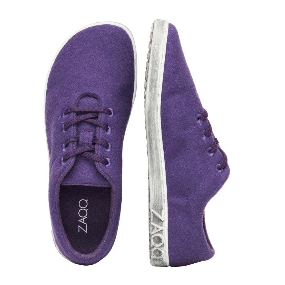 Wir präsentieren den LIQE Purple von ZAQQ: Diese Sneaker zeichnen sich durch ein elegantes, minimalistisches Design aus, sowohl von oben als auch von der Seite betrachtet. Sie zeigen weiße Sohlen mit ZAQQ-Branding und verfügen über eine Barfußsohle für höchsten Komfort. Die stilvollen lila Schnürsenkel verleihen ihnen Eleganz und heben sich wunderschön von einem makellosen weißen Hintergrund ab.