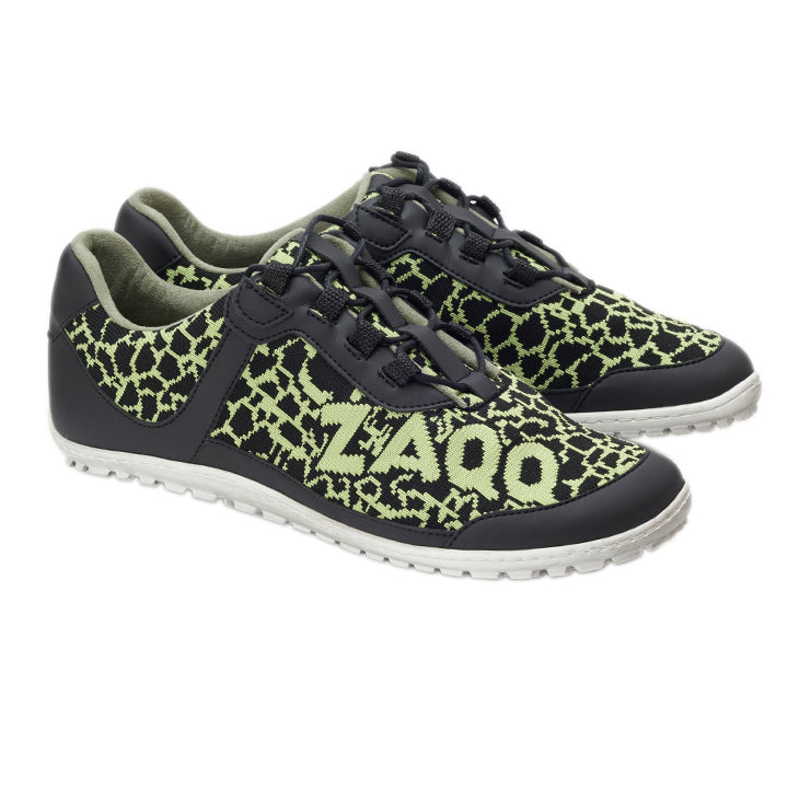 Wir präsentieren die QASEY Green Sneaker von ZAQQ, die eine auffällige Kombination aus Schwarz und Neongrün aufweisen. Diese Schuhe sind aus veganen Materialien gefertigt und zeigen komplizierte Muster mit dem Text „Z400“ an den Seiten. Sie haben weiße Sohlen, schwarze Schnürsenkel und ein Obermaterial aus atmungsaktivem Netzgewebe, das sich elegant vor einem schlichten weißen Hintergrund präsentiert.