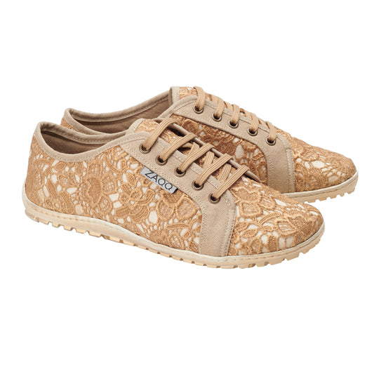 Diese femininen QELLY Beige Gold Sneaker von ZAQQ verfügen über ein beiges Spitzendesign mit Blumenmuster, ergänzt durch passende Schnürsenkel und Besatz. Sie bieten Bewegungsfreiheit und haben eine strukturierte Sohle für Halt, geschmückt mit einem kleinen Markenetikett an der Seite.