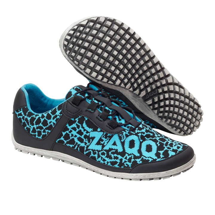 Ein Paar QINGSTON Turquoise Sportschuhe von ZAQQ weist ein elegantes geometrisches Muster in Schwarz und Blau auf, wobei das LAQQ-Logo die Seite ziert. Die Sohle besteht aus veganem Netzgewebe und weist ein strukturiertes Gitterdesign auf. Ein Schuh ist horizontal positioniert, während der andere angewinkelt ist, um seine markante Sohle freizugeben.