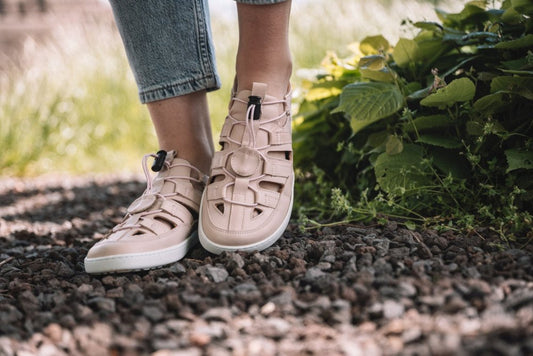 Wir präsentieren die ZAQQ QLEAR Light Pink: ein stilvolles Paar hellrosa Sandalen mit weißer Sohle, mehreren Riemen und einem praktischen Knebelverschluss. Eine Sandale steht aufrecht, während die andere geneigt ist, um ihr griffiges Sohlenmuster zur Geltung zu bringen, was sie perfekt für Outdoor-Abenteuer macht.