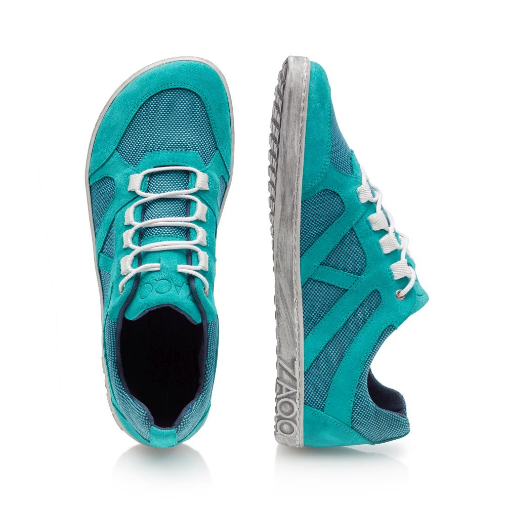 Wir präsentieren den QUSQO Turquoise von ZAQQ: Ein Paar türkisfarbene Sneaker mit weißen Schnürsenkeln und flexiblem Design. Der linke Schuh ist von der Seite zu sehen und zeigt seine strukturierte Sohle, während der rechte Schuh von oben zu sehen ist – Ihr idealer Running Buddy.