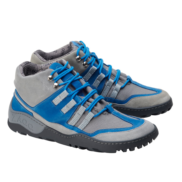 Wir präsentieren die ZAQQ ESQAPE Grey Blue Waterproof Sneaker mit robuster Sohle und blauen Schnürsenkeln. Diese Schuhe bestehen aus einer Kombination aus Mesh und Leder und bieten ein sportliches Aussehen gepaart mit außergewöhnlicher Haltbarkeit. Die wasserdichte Innenmembran sorgt dafür, dass Ihre Füße bei jedem Abenteuer trocken bleiben.