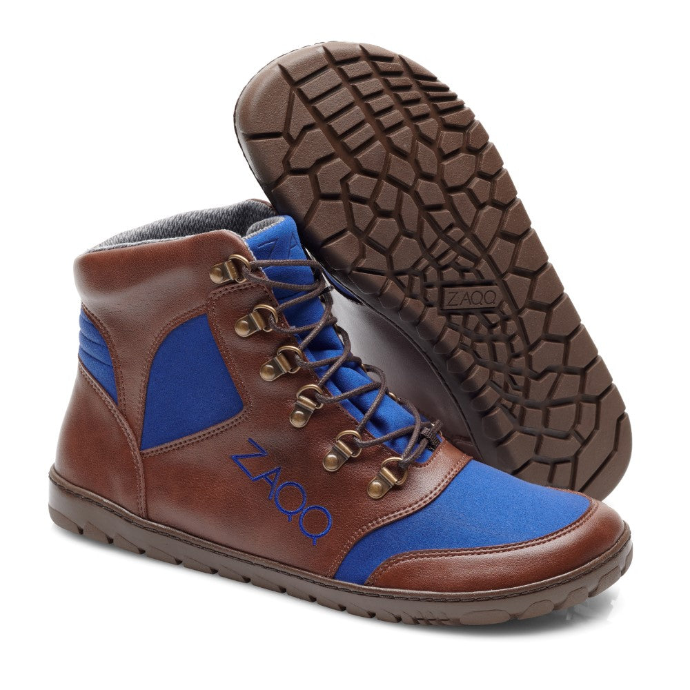 Wir präsentieren die wasserdichten HIQE Brown Blue Sneaker von ZAQQ mit einer robusten und flexiblen Kautschuksohle. Diese High-Top-Sneaker zeichnen sich durch braune Lederakzente, blaue Stoffeinsätze und braune Schnürsenkel aus. Eine wasserdichte Innenmembran sorgt für dauerhafte Haltbarkeit. Der Markenname ZAQQ ist deutlich sichtbar an der Seite und der Sohle der Schuhe angebracht.