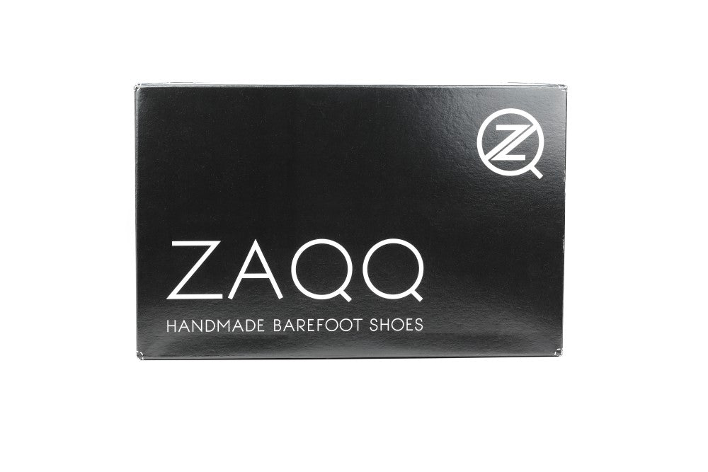 Auf einem eleganten schwarzen Schuhkarton steht der Markenname ZAQQ in fetten weißen Buchstaben. Darunter steht elegant „Handgefertigte Barfußschuhe“. Das ZQ-Logo ziert die obere rechte Ecke und weist auf die MINIQ Black-Linie hin. Ideal, um Ihrem Sommerlook Stil und Komfort zu verleihen.