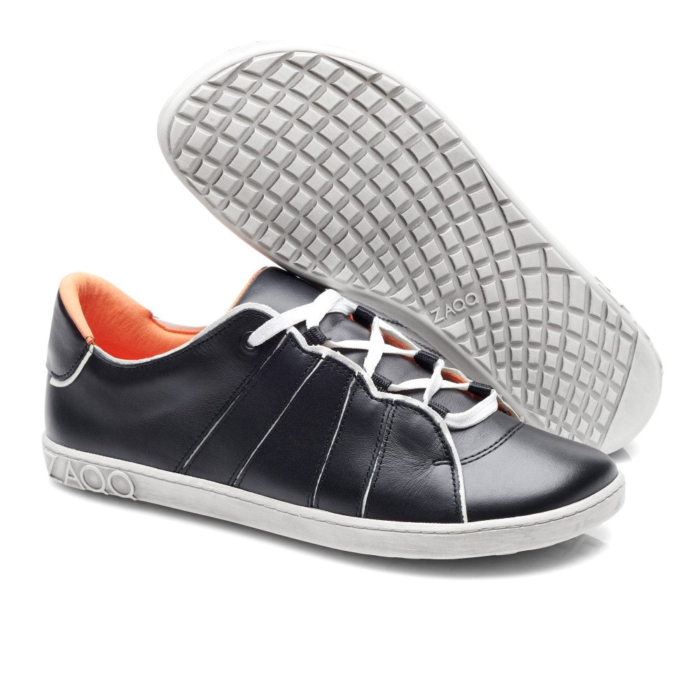 Wir präsentieren den ZAQQ QQQ Low Black White: ein Paar schwarze Leder-Sneaker für außergewöhnlichen Tragekomfort. Diese Barfußschuhe haben weiße Sohlen und Schnürsenkel, eine orangefarbene Innenseite und ein Sohlendesign mit Gittermuster. Die elegante Prägung des Wortes ZAQQ ziert die Ferse.